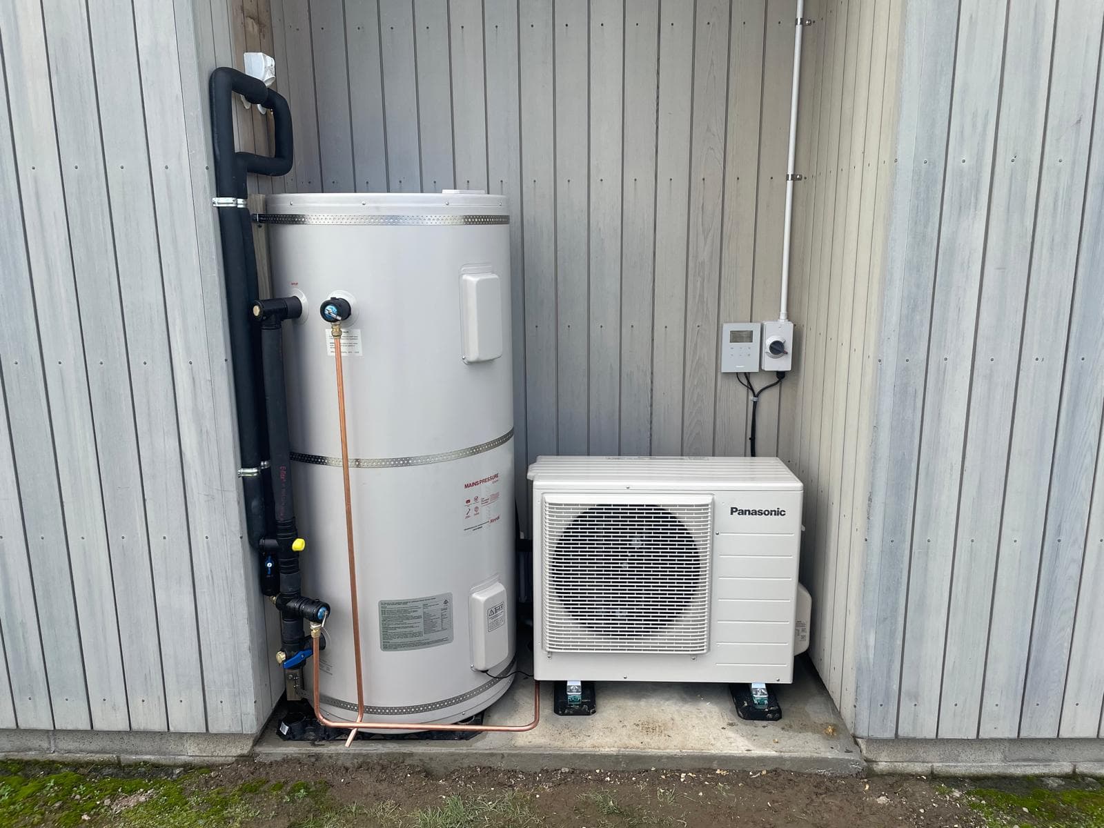 Mains-pressure hot water cylinder plumbed in copper alongside a Panasonic heat pump outdoor unit