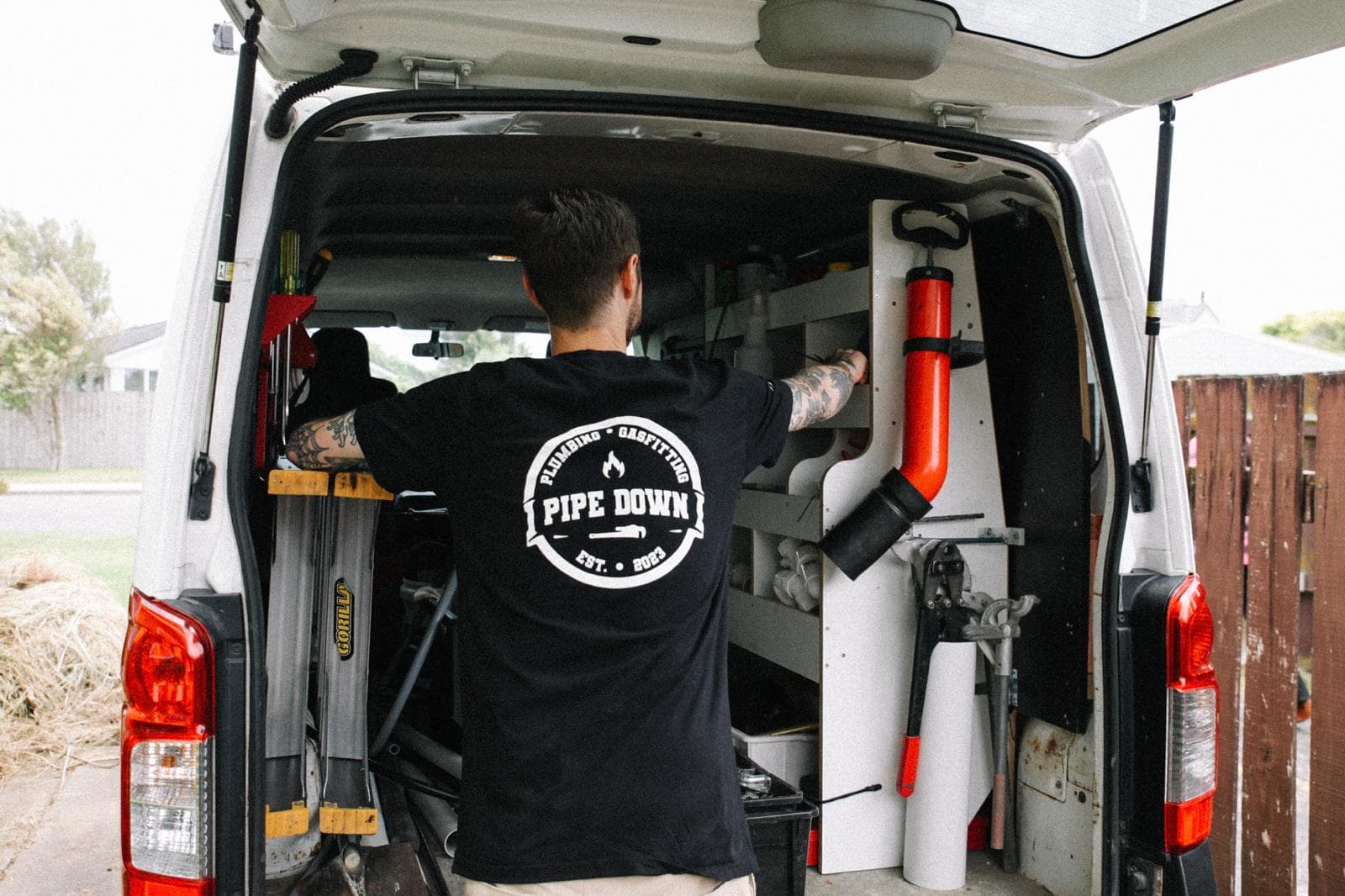 Tony organising tools in the back of the Pipe Down Plumbing van